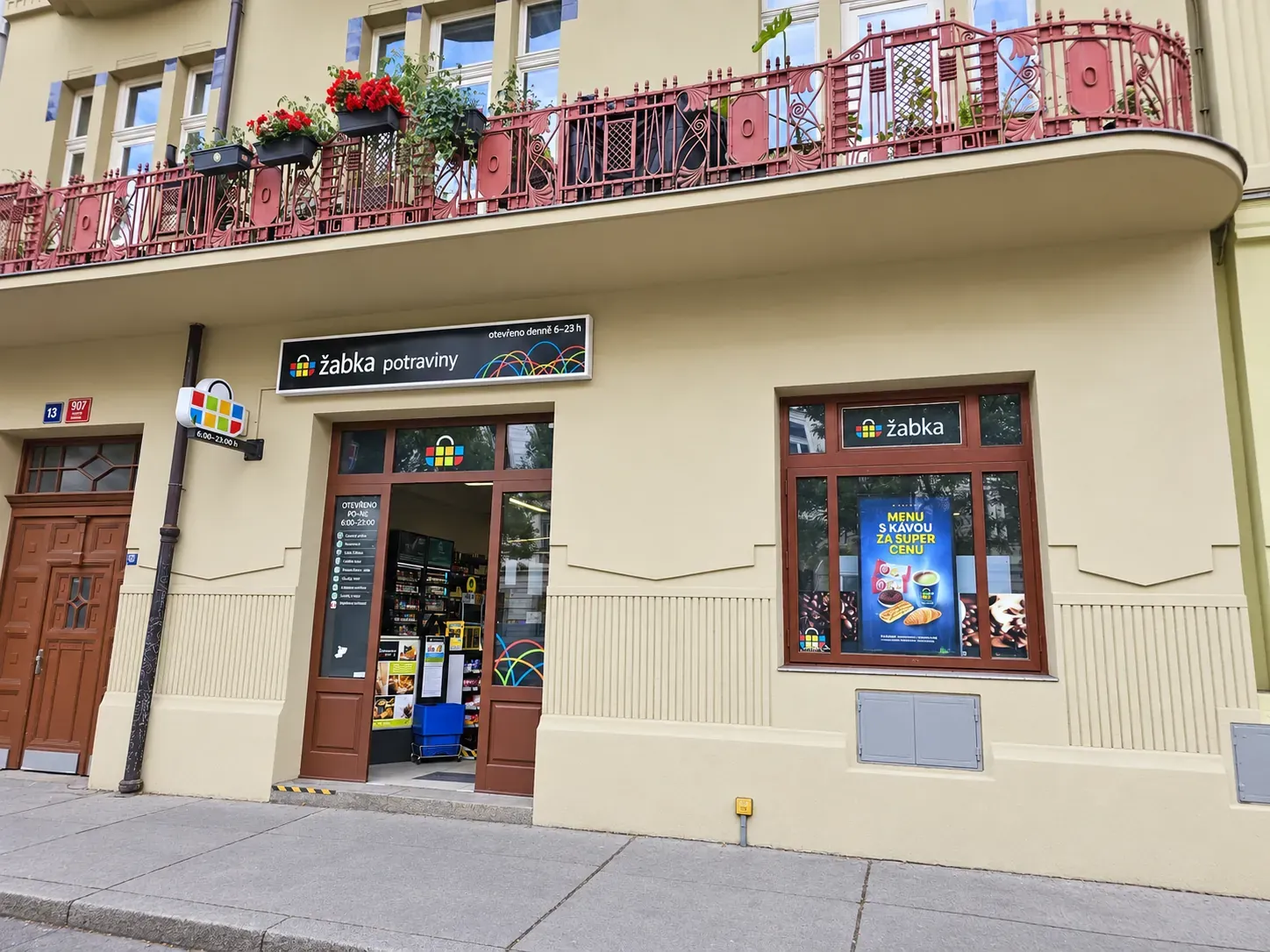 A Žabka convenience store with promotional screens in the windows